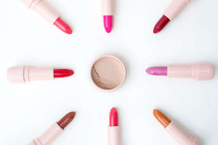 beautiful top view of loose powder and  various colors lipstick on white backgroundの写真素材