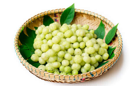 top view fresh Phyllanthus acidus or  star gooseberry with green leaves on bamboo basket backgroundの写真素材