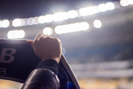 Silhouettes and hands of fans at a football stadium