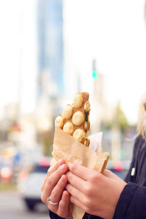 Hong Kong waffle, with syrup, the girl holds in her hands.の写真素材