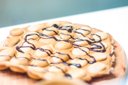 Cook prepares Hong Kong waffles with ice cream, jam and fruit. Young woman holding Hong Kong bubble wafersの写真素材