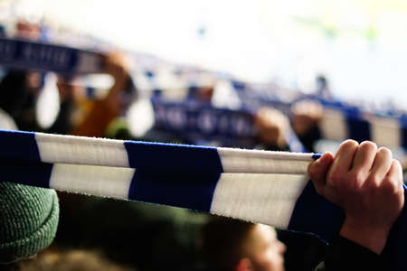 Overjoyed football fan holding a scarf and cheeringの写真素材