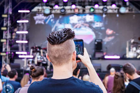 Audience recording video of band on mobile phone in concert.の写真素材