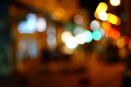 Bright circles from streetlamps on defocused photo of night street.