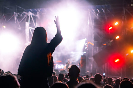 Girl on shoulders in the crowd at a music festival.