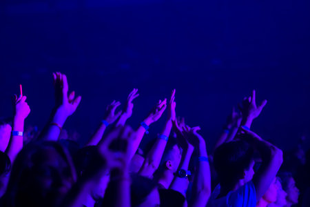 silhouettes of concert crowd in front of bright stage lights