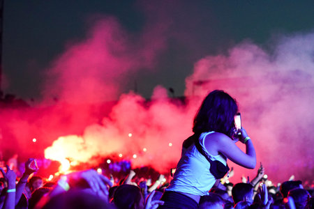 Crowd at a music concert, audience raising hands up