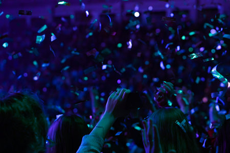 Crowd at a music concert, audience raising hands up