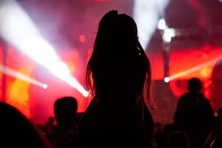 Girls with hands up dancing, singing and listening the music during concert show on summer music festivalの写真素材