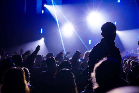 Girls with hands up dancing, singing and listening the music during concert show on summer music festivalの写真素材