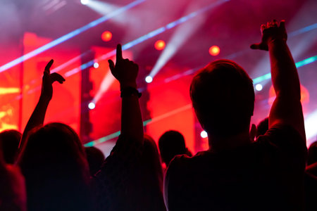 Crowd at a music concert, audience raising hands up