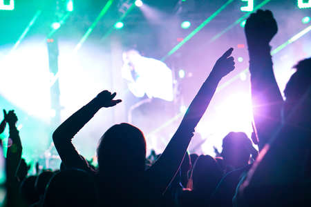 crowd cheering and hands raised at a live music concertの写真素材