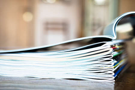Closeup background of a pile of old magazines with bending pagesの写真素材