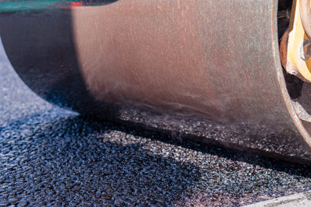 steamroller compact flatten out the asphalt tar