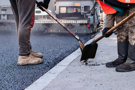 Workers remove the old pavement for laying new asphalt. Road repair