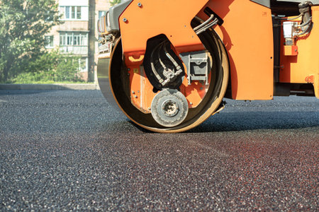 steamroller compact flatten out the asphalt tar