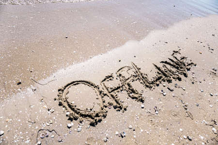 Online word is written on the beach sandの写真素材
