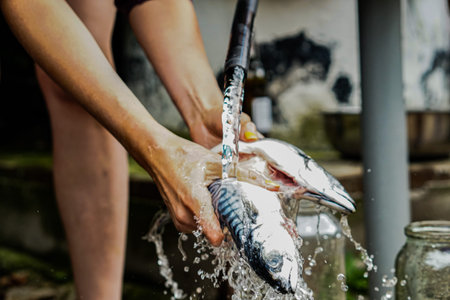 Women is cleaning and washing fish with hands