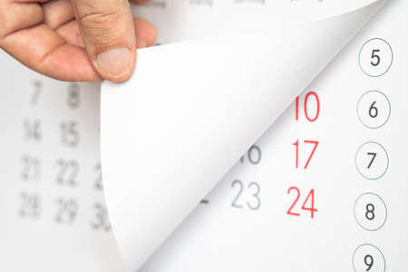 The man's hand turns the calendar.の写真素材