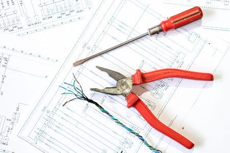 Various electrical tools and wires on a paper diagram, composition about home electrics