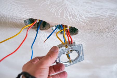 Hands of electrician installing socket in gypsum wallの写真素材