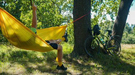 cyclist rests on a hammock, yellow hammock and open airの写真素材