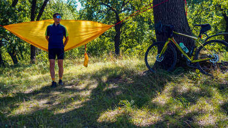 cyclist rests on a hammock, yellow hammock and open airの写真素材