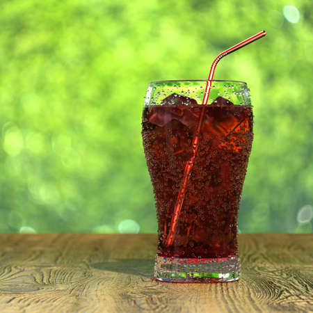 Very high resolution 3d rendering of a glass of fresh iced cola on a wood tableの写真素材