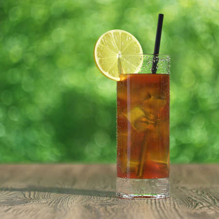 Very high resolution 3d rendering of a glass of fresh iced tea on a wood tableの写真素材
