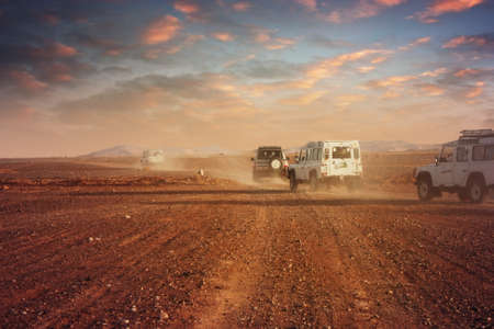 Cars in the desert at sunsetの写真素材