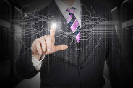 Man pressing digital button in a futuristic touchscreen monitorの写真素材