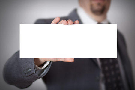 Business businessman handing a blank card over white の写真素材