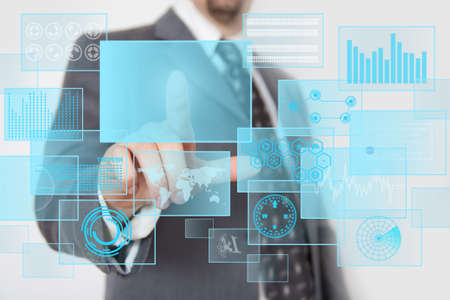 Man pressing digital button in a futuristic touchscreen monitorの写真素材