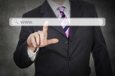 Man pressing digital button in a futuristic touchscreen monitorの写真素材