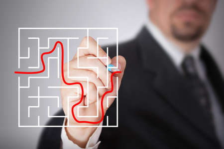 Businessman sketching the solution of a labirinthの写真素材