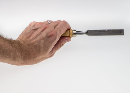 human hand working with chisel tool on white backgroundの写真素材