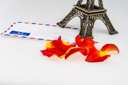 Eiffel tower and envelope with orange rose isolated on whiteの写真素材