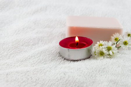 Spa concept with rose soap on white towel decorated by cutter flower and red tea candleの写真素材