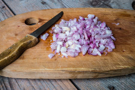 Red Onion Slices  on cutting board with old wooden backgroundの写真素材