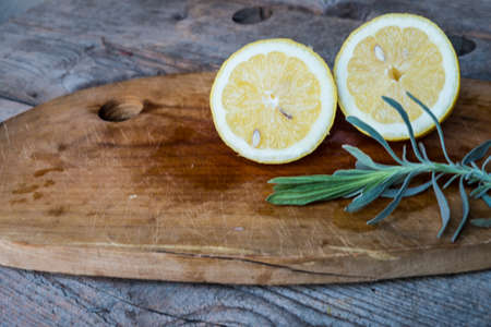 Lemon on cutting board, old wood backgroundの写真素材