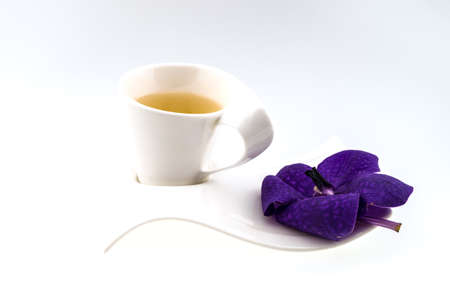 Tea time with  purple orchid on white backgroundの写真素材