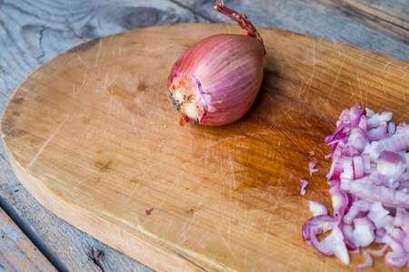 Red Onion Slices  on cutting board with old wooden backgroundの写真素材