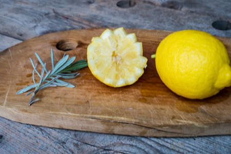Lemon on cutting board, old wood backgroundの写真素材