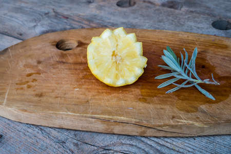 Lemon on cutting board, old wood backgroundの写真素材