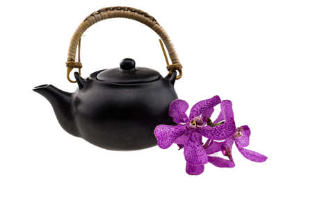 Black tea pot with Pink mokara orchids isolated on white backgroundの写真素材