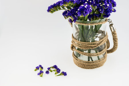 Statice flower in  glass canister and petal  isolated on whiteの写真素材