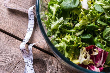 Salad in glass with measuring tape on wood backgroundの写真素材