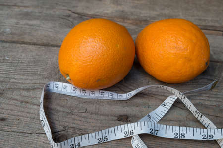 Orange  with measuring tape on old wood backgroundの写真素材