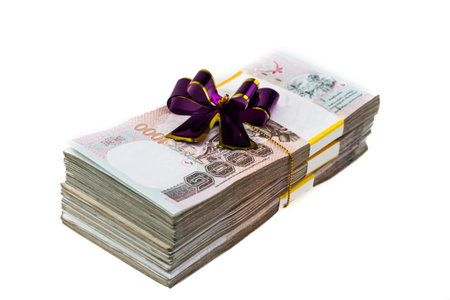 Thailand money banknotes stacked wrapping with purple bow isolated.の写真素材