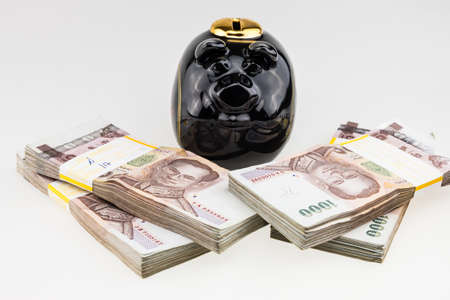 Black piggy bank with Thailand money banknotes stacked isolatedの写真素材